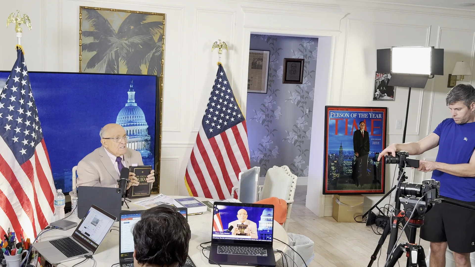 Stephen Schumacher adjusts a camera while Ted Goodman operates production controls and Rudy Giuliani appears on the America’s Mayor Live set
